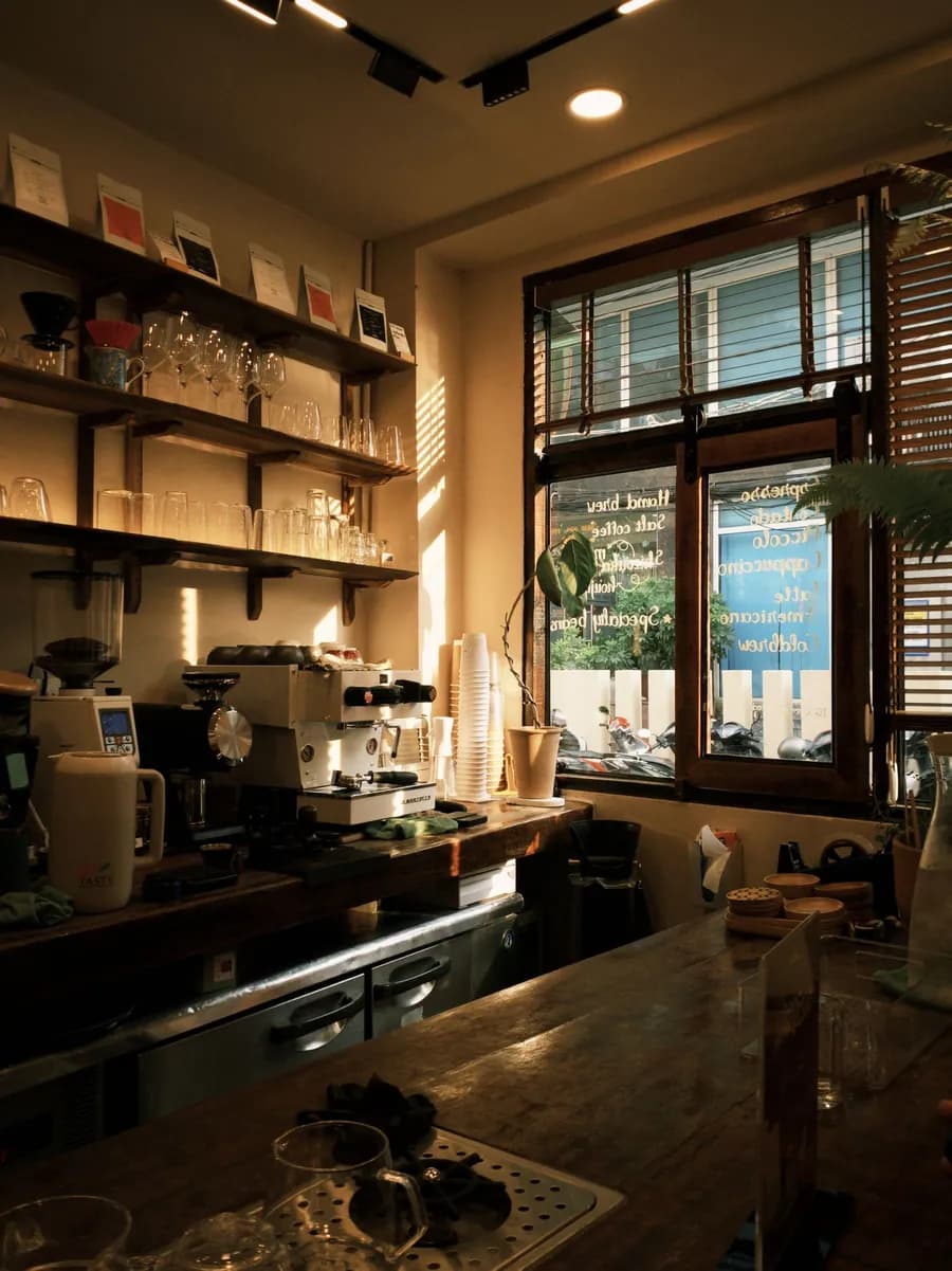 Le comptoir du café, avec la machine à espresso baignée de lumière